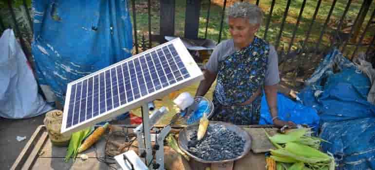 75 year old woman using solar power to grill corns